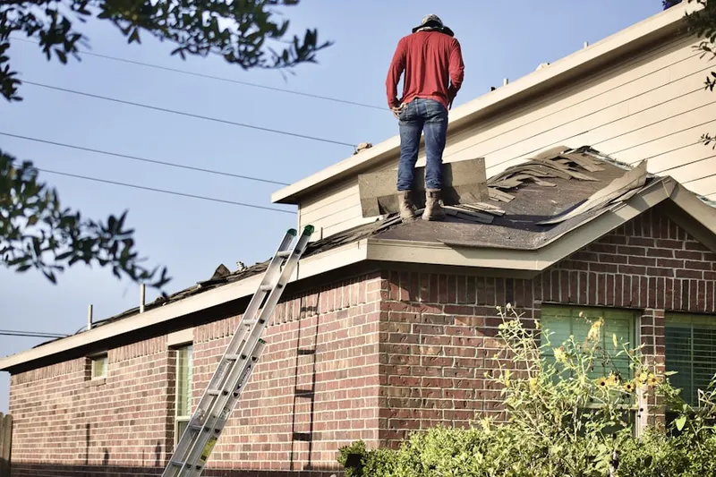 Professional roofer working on a residential roof in Huntington South